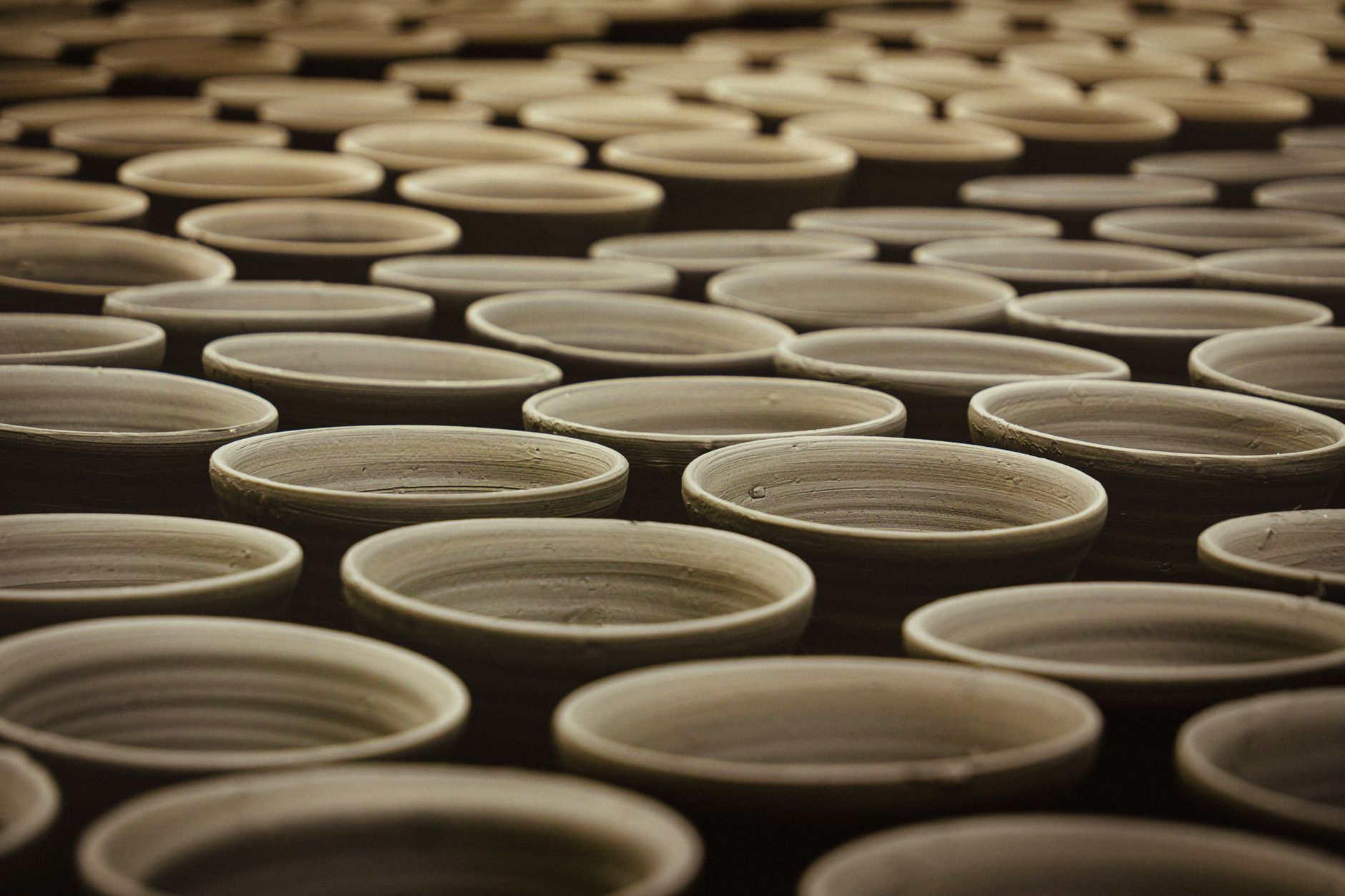 Un laboratorio artigianale con ceramiche fatte a mano su uno scaffale in legno
